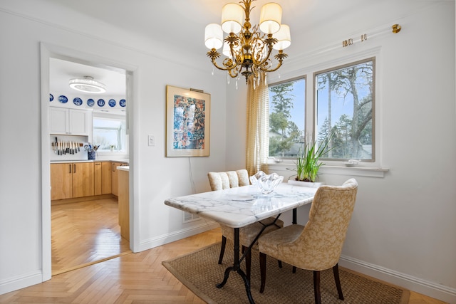 dining space with baseboards and a chandelier