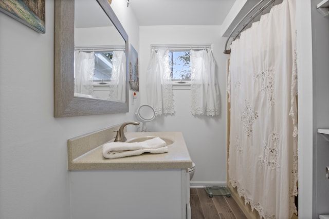 full bath featuring a shower with curtain, wood tiled floor, toilet, baseboards, and vanity