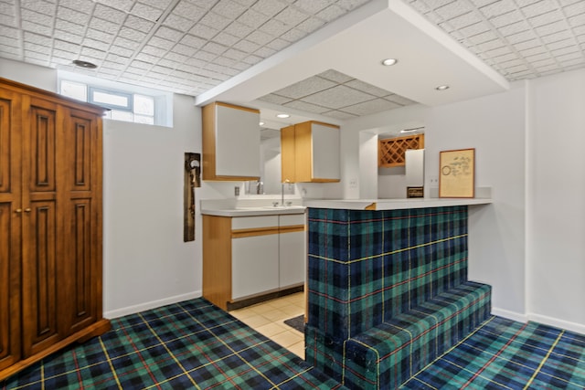 kitchen featuring recessed lighting, baseboards, light tile patterned floors, and light countertops