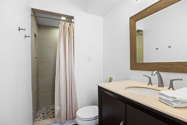 full bathroom featuring vanity, toilet, and a tile shower