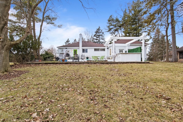 rear view of property with a patio and a lawn