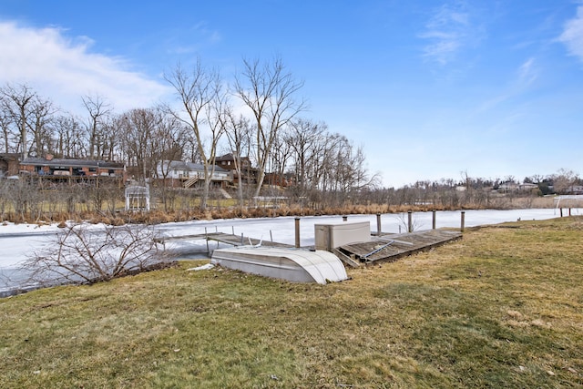 view of dock with a yard and a water view