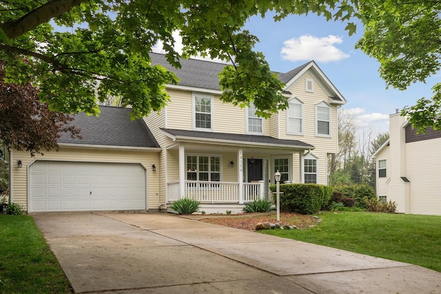 traditional-style house with roof with shingles, a porch, concrete driveway, a front yard, and a garage