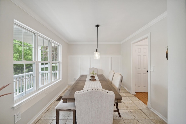 dining room with light tile patterned floors, baseboards, and crown molding