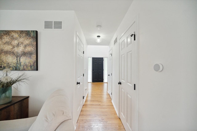 hall featuring light wood-style flooring and visible vents