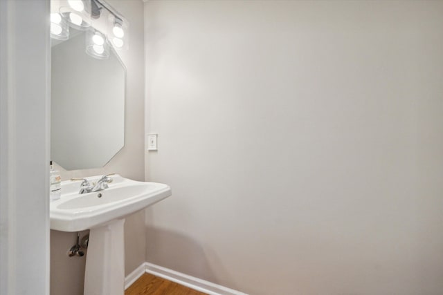 bathroom featuring a sink, baseboards, and wood finished floors