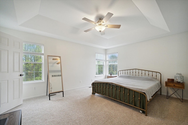 bedroom featuring carpet, baseboards, a raised ceiling, and a ceiling fan