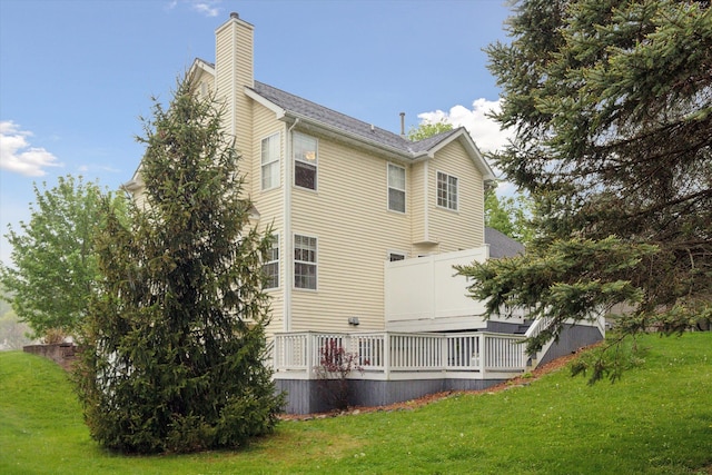 back of property with a lawn and a chimney