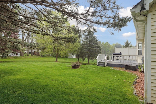 view of yard featuring a deck, a fire pit, and cooling unit