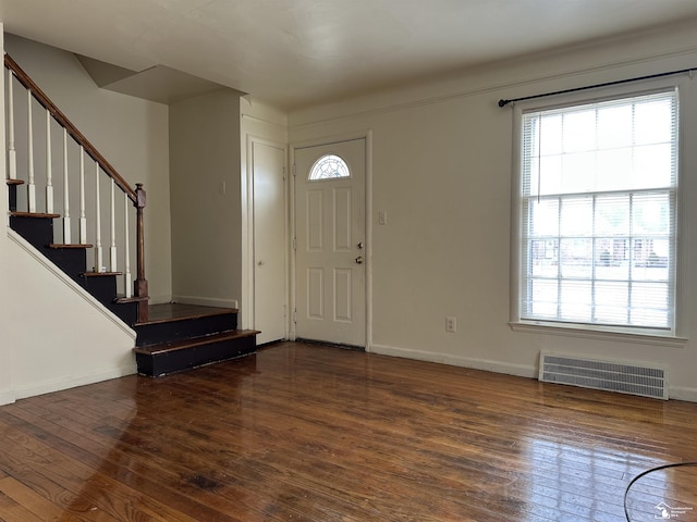 foyer with a healthy amount of sunlight, wood-type flooring, stairs, and visible vents