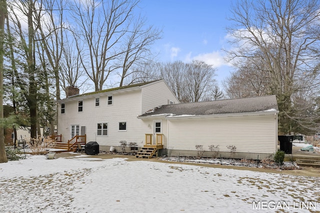 snow covered property with a chimney