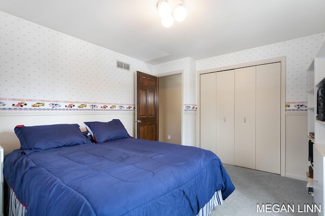 carpeted bedroom featuring a closet, visible vents, and wallpapered walls