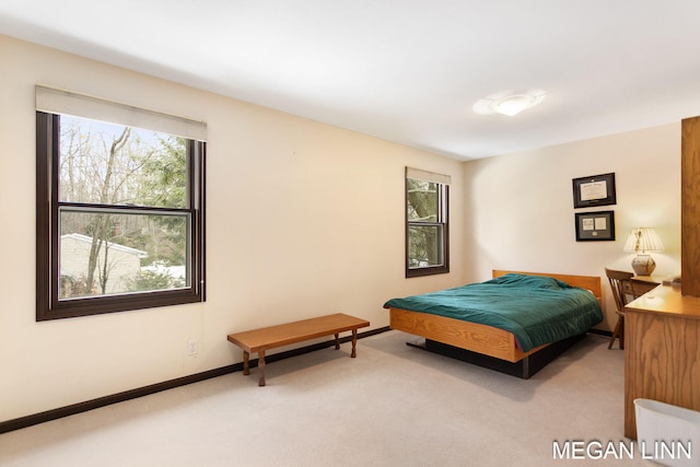 bedroom with light carpet and baseboards