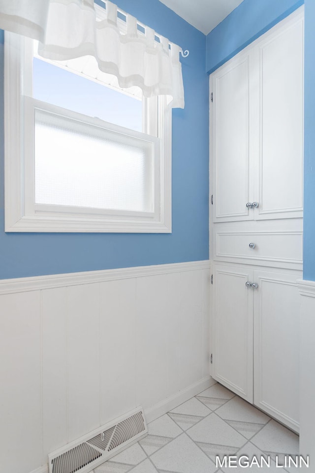 interior space with visible vents and wainscoting