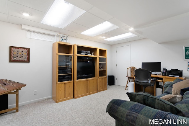 carpeted office space with a paneled ceiling and baseboards