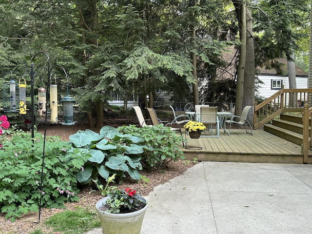 view of yard with outdoor dining area, a wooden deck, and fence