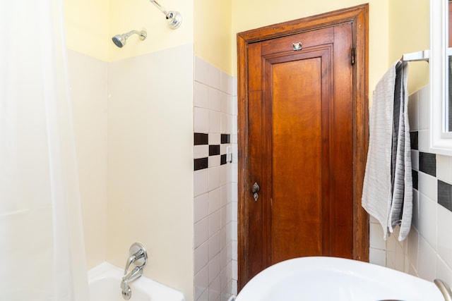 bathroom with tile walls and bathing tub / shower combination