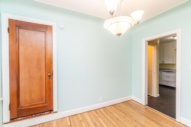 unfurnished room with light wood-type flooring and baseboards