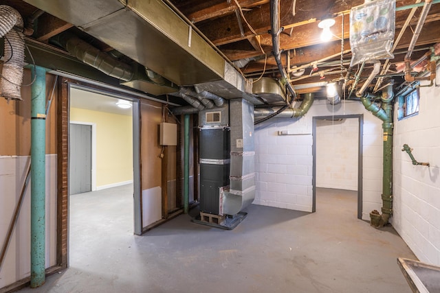 unfinished basement featuring visible vents and heating unit