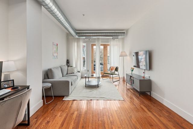 living area with baseboards and hardwood / wood-style floors