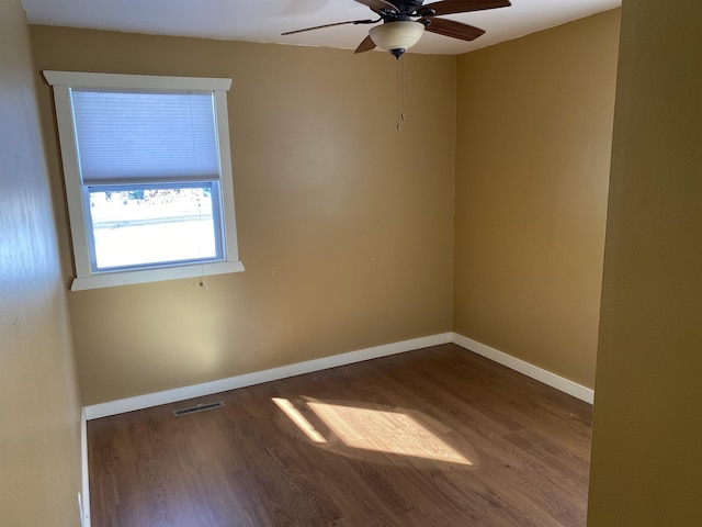 spare room with visible vents, ceiling fan, baseboards, and wood finished floors