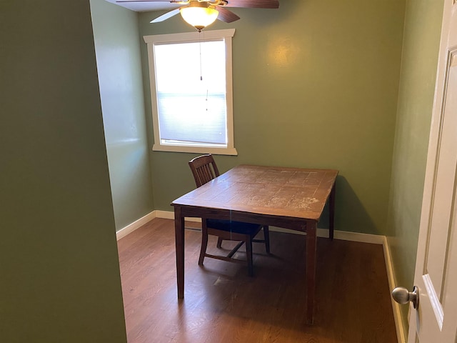 dining room with a ceiling fan, baseboards, and wood finished floors