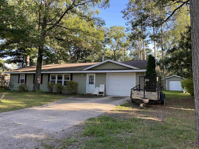 ranch-style house with a garage, concrete driveway, and a front lawn