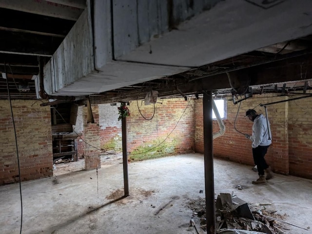 basement featuring brick wall