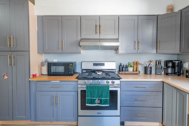 kitchen with ventilation hood, light countertops, gray cabinetry, stainless steel range with gas cooktop, and black microwave
