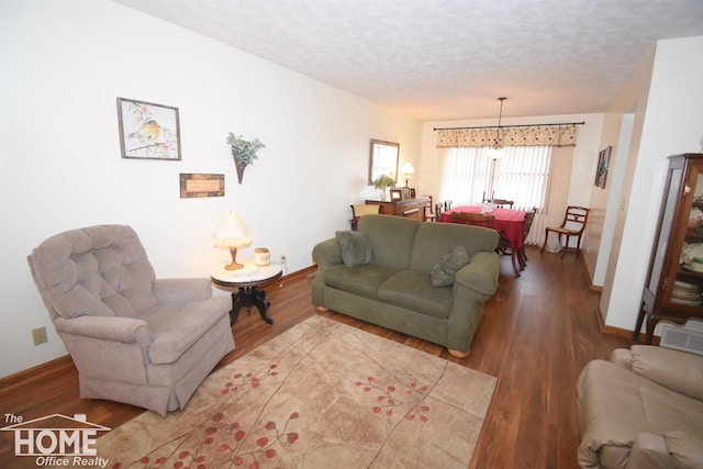 living area with a textured ceiling, wood finished floors, and baseboards