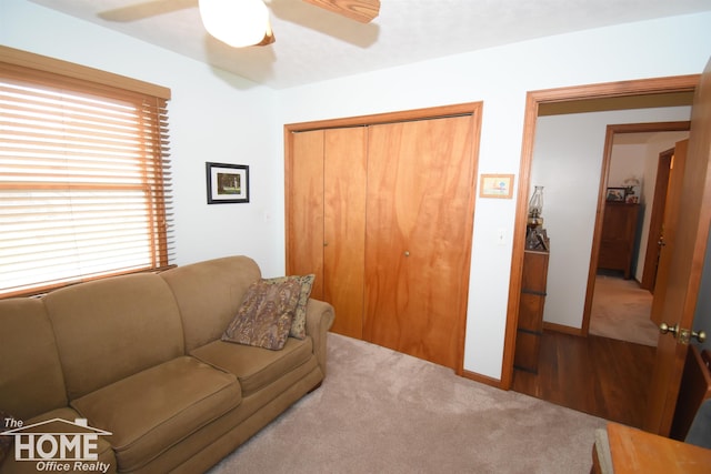 carpeted living area featuring a ceiling fan