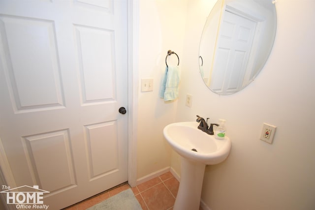 bathroom with tile patterned flooring, a sink, and baseboards