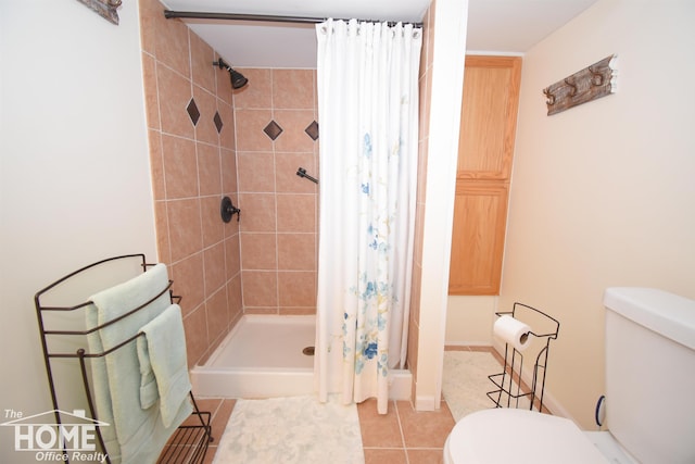 bathroom with toilet, a shower stall, and tile patterned flooring