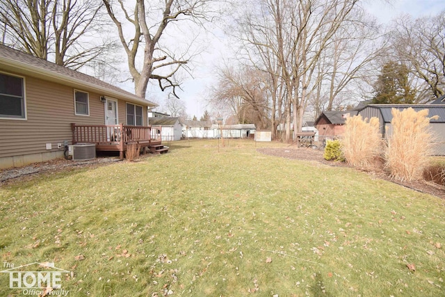 view of yard with a deck, central AC unit, and an outbuilding