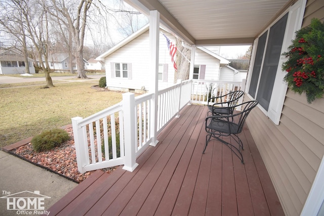 wooden deck featuring a residential view and a yard