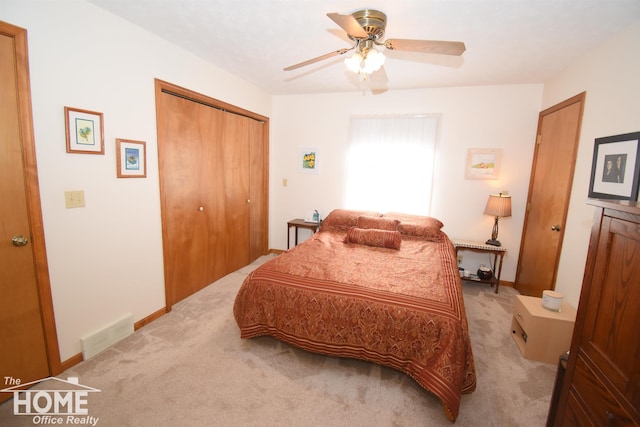 bedroom featuring ceiling fan, light carpet, visible vents, baseboards, and a closet