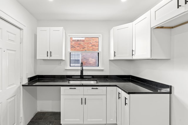 kitchen featuring white cabinetry and a sink