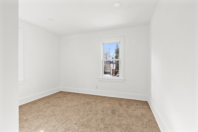 empty room featuring baseboards and carpet flooring