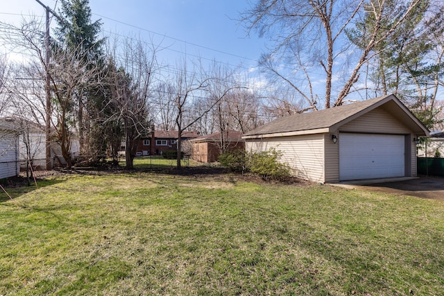 view of yard with an outdoor structure, fence, and a detached garage