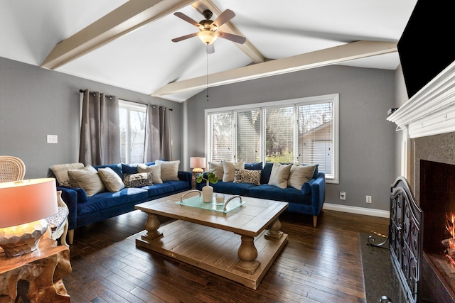 living area featuring a high end fireplace, baseboards, lofted ceiling with beams, hardwood / wood-style floors, and a ceiling fan