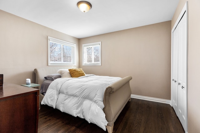 bedroom featuring a closet, baseboards, and dark wood-style floors