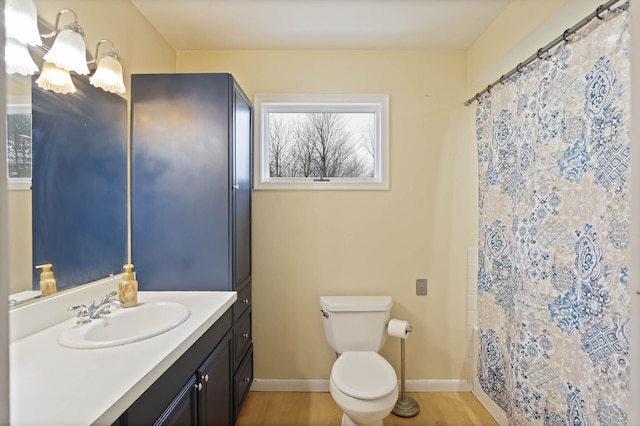 full bathroom featuring baseboards, toilet, wood finished floors, and vanity