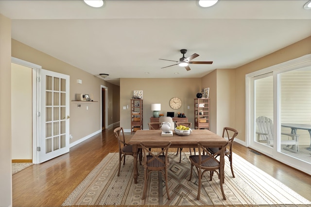 dining area featuring a ceiling fan, baseboards, and wood finished floors