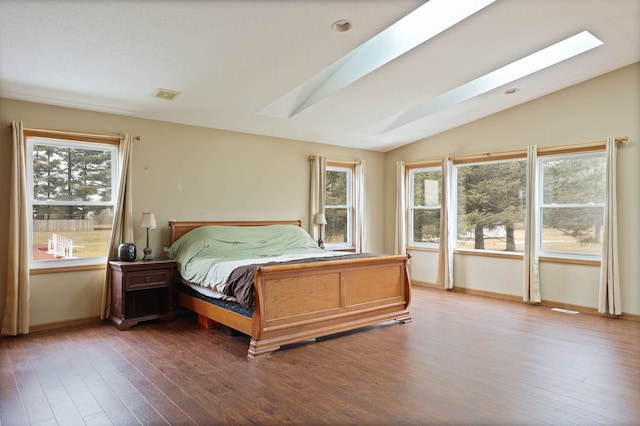 bedroom with visible vents, vaulted ceiling with skylight, and wood-type flooring