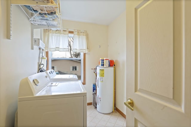 clothes washing area with light floors, baseboards, laundry area, water heater, and washer and dryer