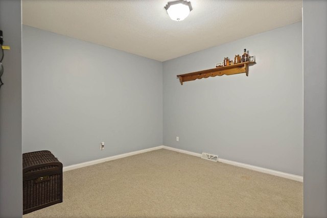 empty room featuring visible vents, baseboards, and carpet