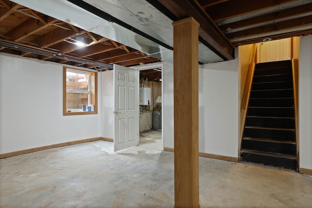 below grade area featuring baseboards, stairs, and water heater