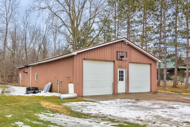 snow covered garage featuring a detached garage