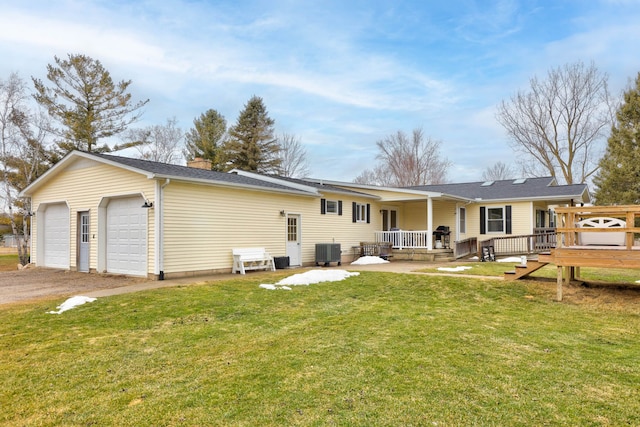 rear view of house featuring a wooden deck, a chimney, a garage, central air condition unit, and a lawn