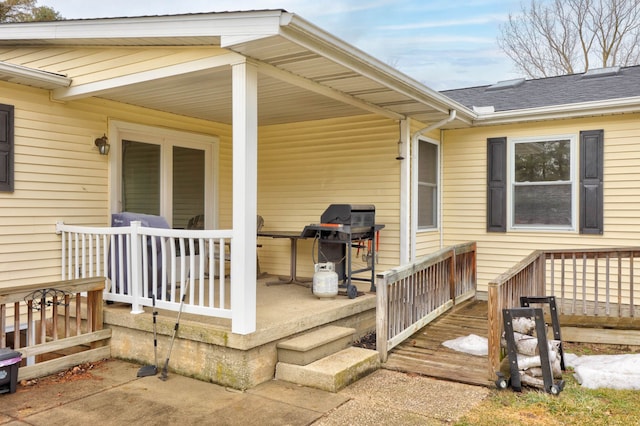 property entrance with covered porch and a shingled roof